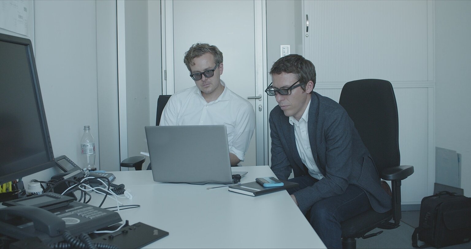 Zwei Männer schauen in einem Büro auf einen Bildschirm – Frederik Obermaier (links) und Bastian Obermayer sichten das Ibiza-Material mit Spezialbrillen