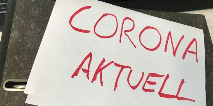 Aktenordner mit einem A4-Papier „Corona aktuell“ – 